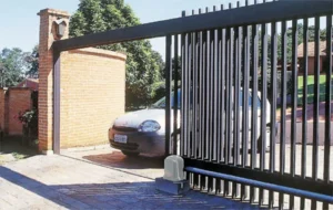 Carro saindo de uma casa, tendo em destaque um portão eletrônico